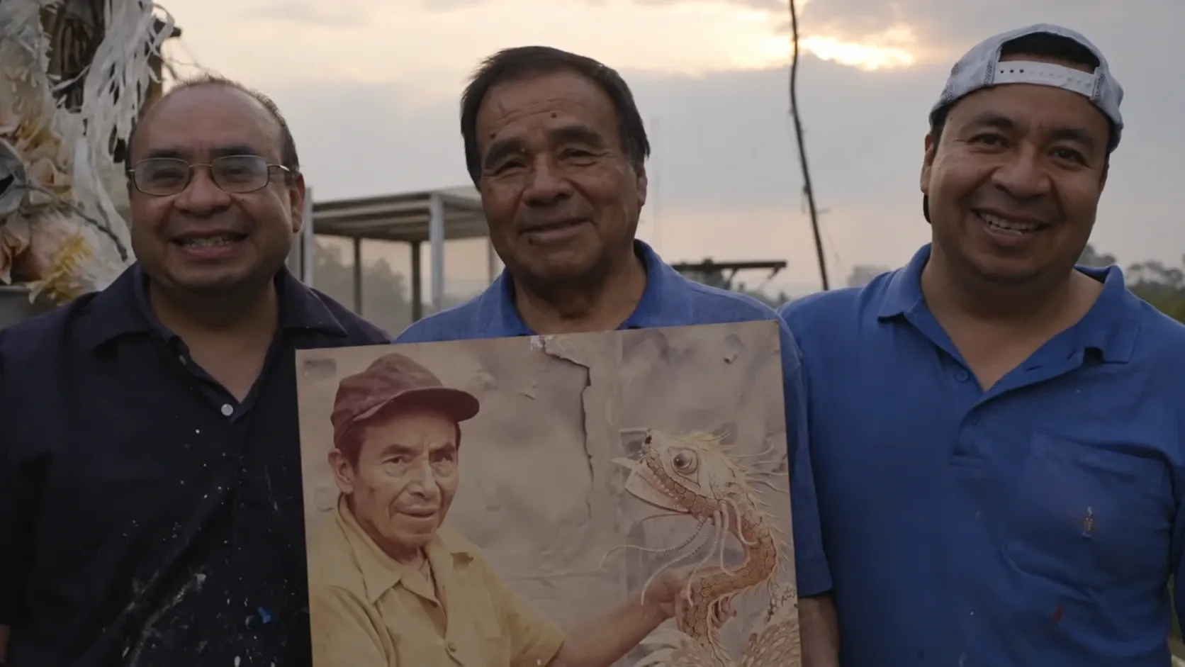 Leonardo Linares Vargas, Felipe Linares Mendoza and Felipe Linares Vargas hold a portrait of Pedro Linares López outside the workshop.