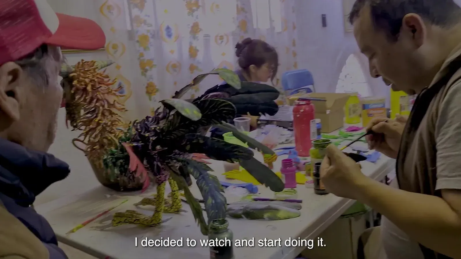 Felipe Linares Mendoza and Felipe Linares Vargas with a rooster alebrije on the workshop table.