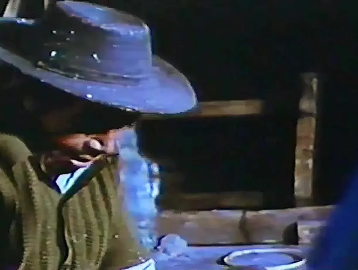 Un hombre con sombrero trabaja el armazón de carrizo de un Judas en el taller, en 1975.