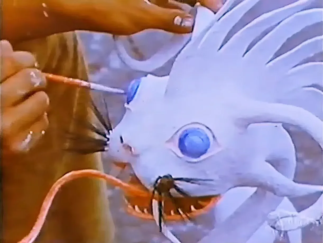 A hand paints the eye of a still-white alebrije with a fine brush, in 1975.