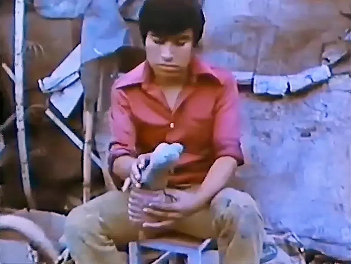 A young man in a red shirt models a cartonería figure in Pedro Linares’s workshop, in 1975.